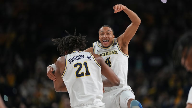 Michigan's Nimari Burnett (4) and Morez Johnson Jr. celebrate after defeating UConn in the...